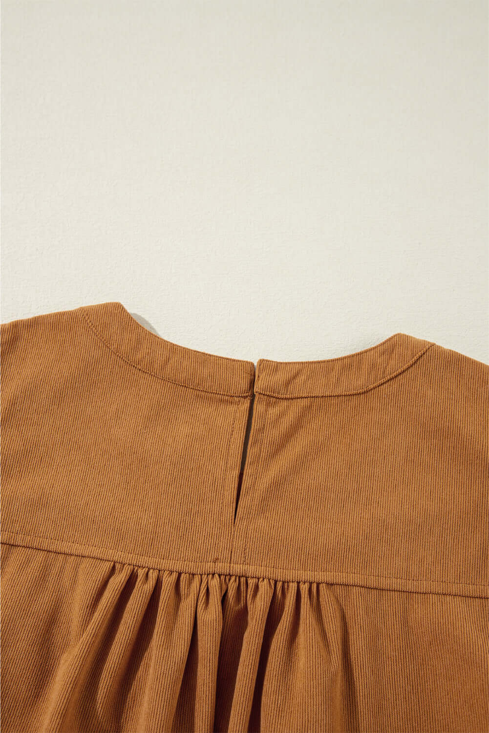 Close-up of copper DESERT WINDS Dress showcasing luxurious corduroy fabric and delicate pleating at the back neckline.