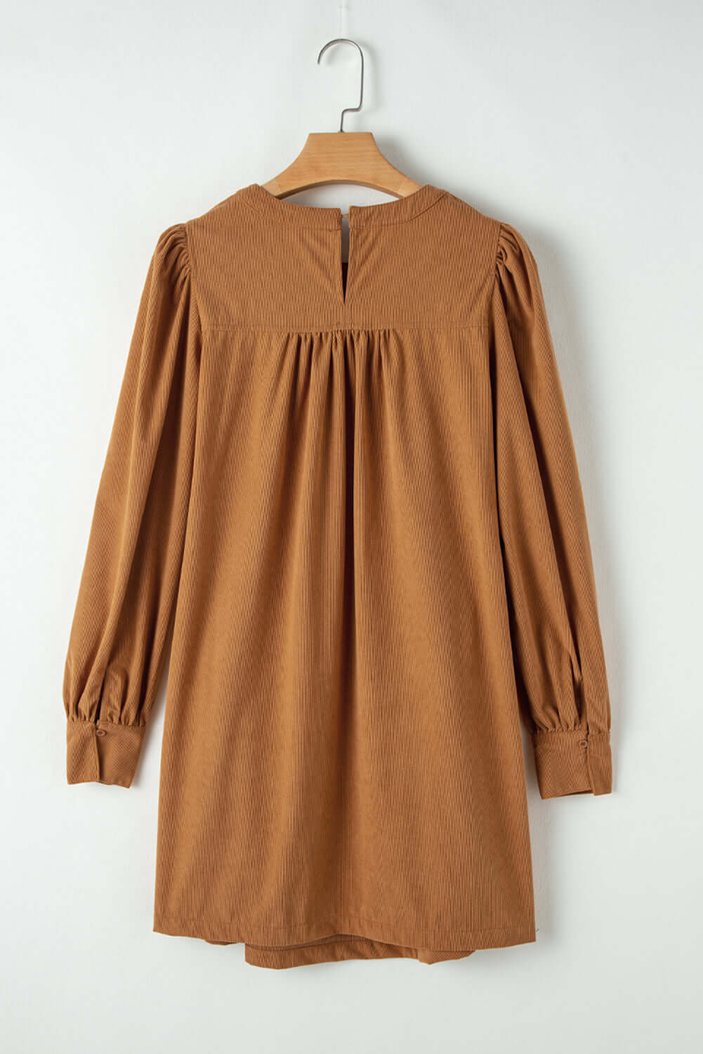 Copper corduroy dress with puff sleeves and pleating, offering a luxurious and sophisticated look.