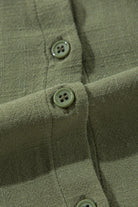 Close-up of Jungle Green dress with buttoned front detail and textured fabric.