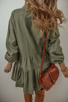 Jungle Green mini dress with puff sleeves, tiered pleats, and a buttoned front, styled with a brown leather bag and boots.