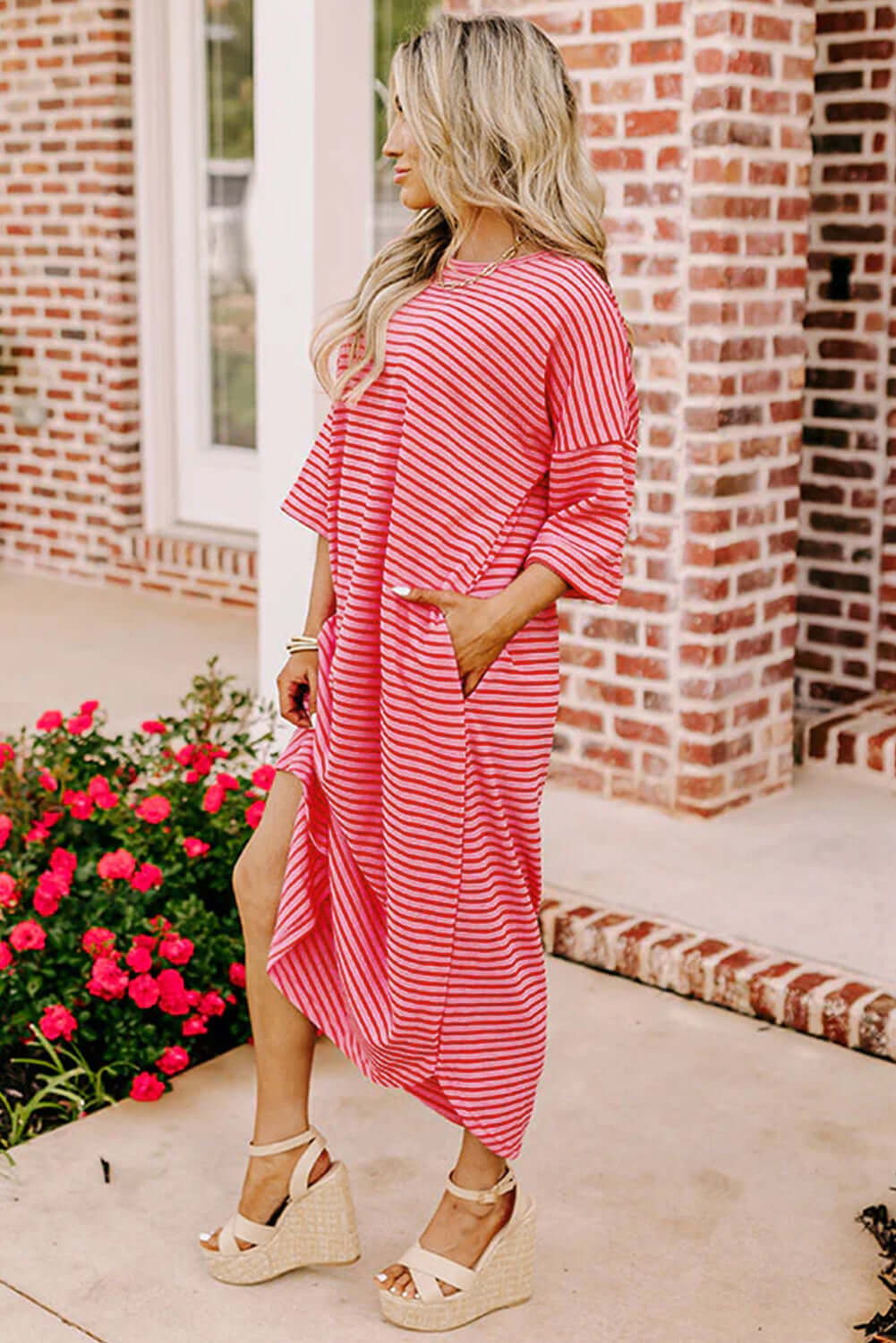 Model wearing the Strawberry Sundays Dress, featuring a striped pattern and drop shoulder design, in a stylish outdoor setting.