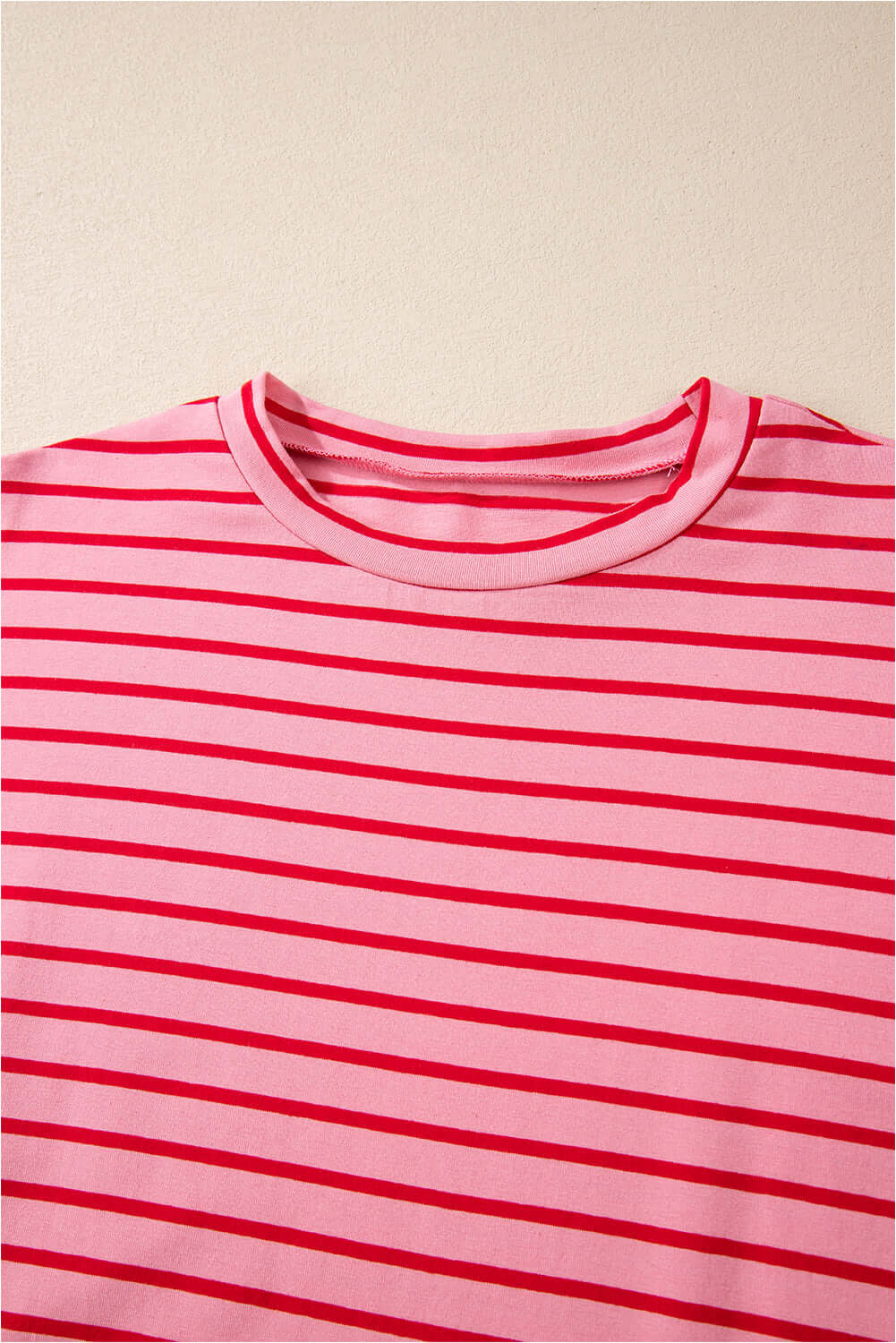 Close-up of the crew neck and striped pattern on the Strawberry Sundays Dress in pink and red hues.