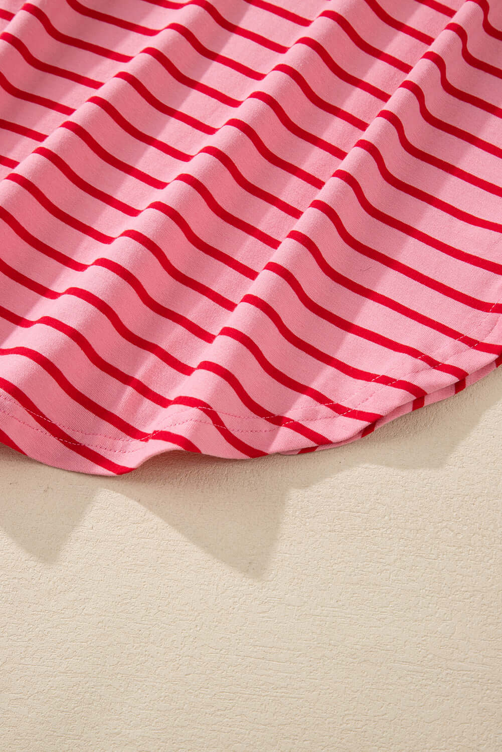 Close-up of the pink striped fabric of the Strawberry Sundays Dress, showcasing its soft texture and elegant pattern.