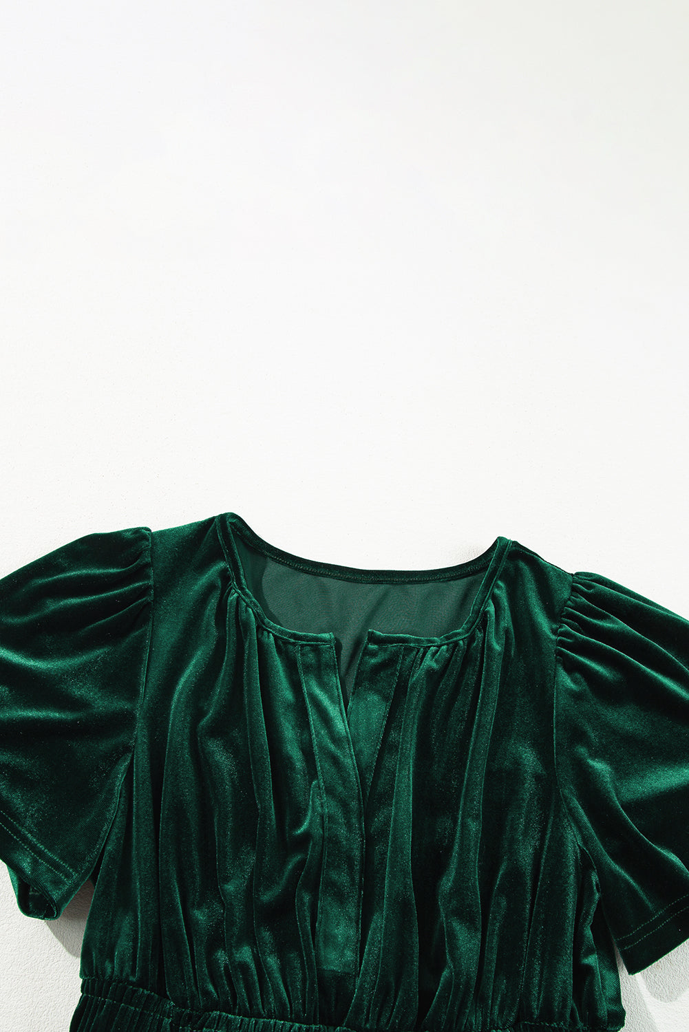 Elegant emerald velvet maxi dress with short sleeves and a V-neck, featuring a chic boho-inspired tiered design.