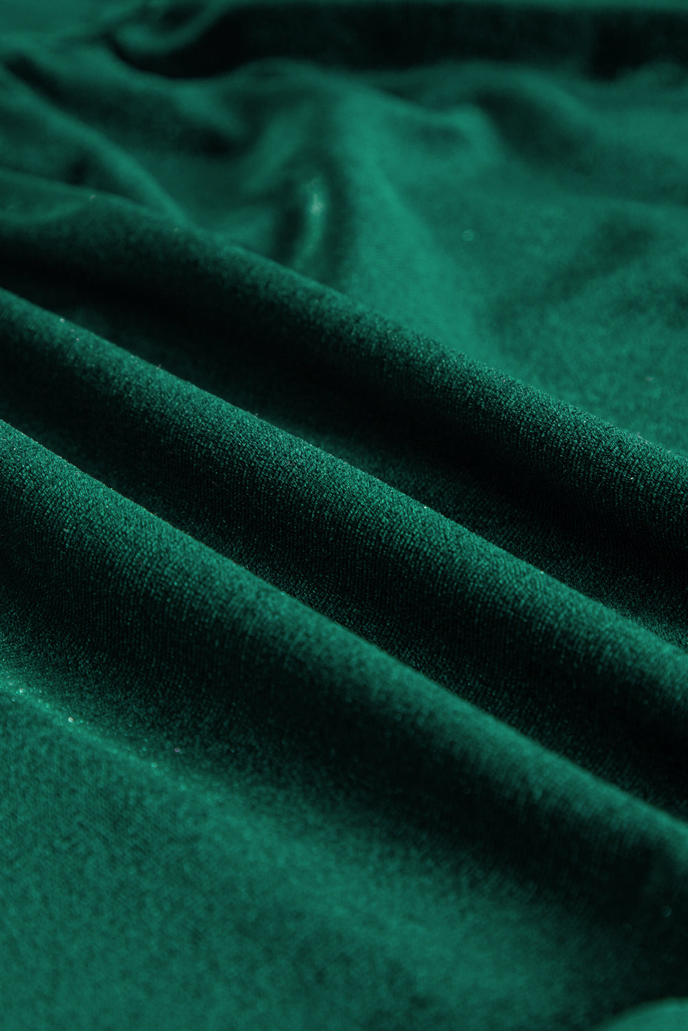 Luxurious emerald velvet fabric close-up, highlighting its rich texture and vibrant color for the Elegant Emerald Maxi dress.