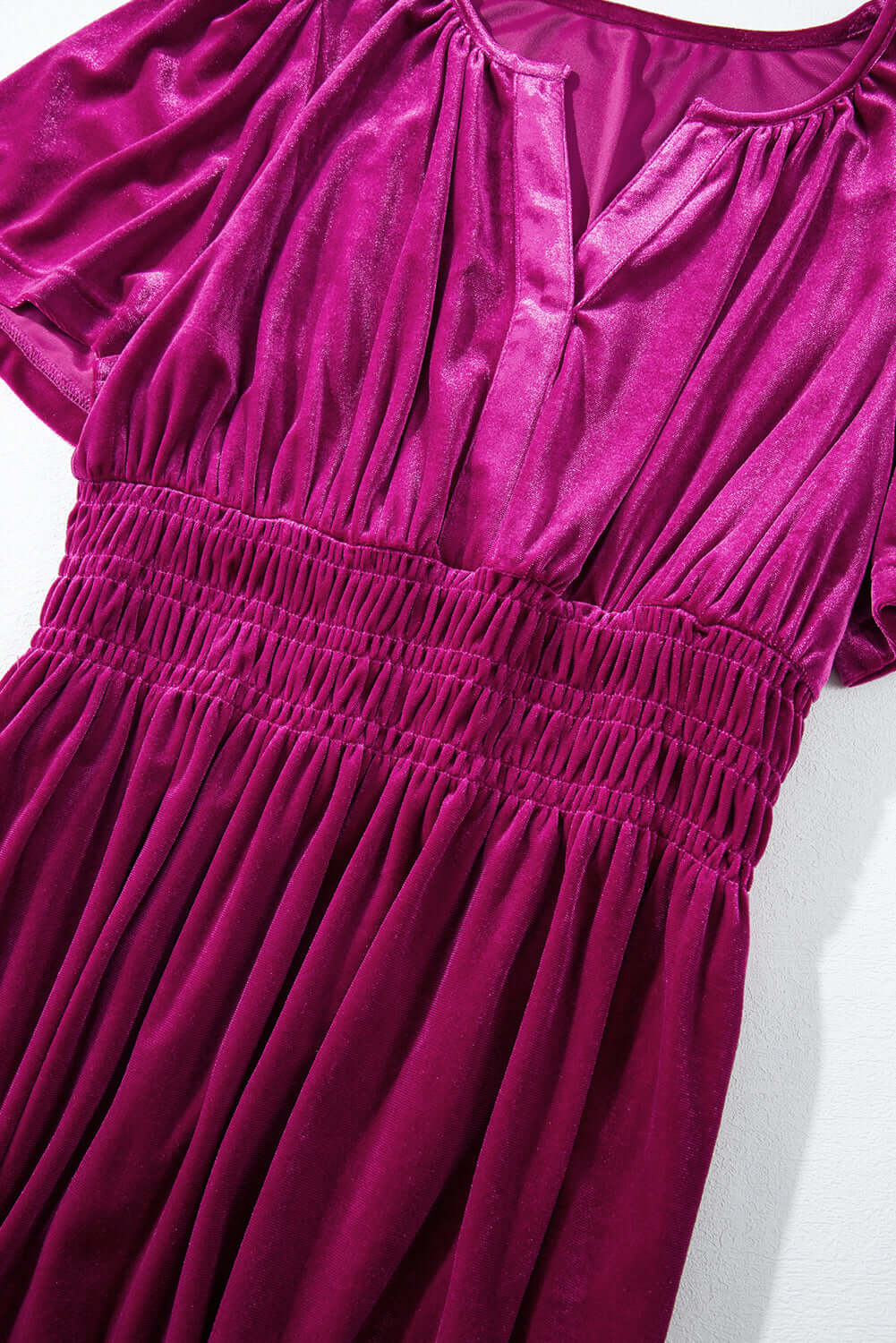 Elegant magenta velvet dress with short sleeves, v-neck cut, and tiered design perfect for a stylish and comfortable boho look.