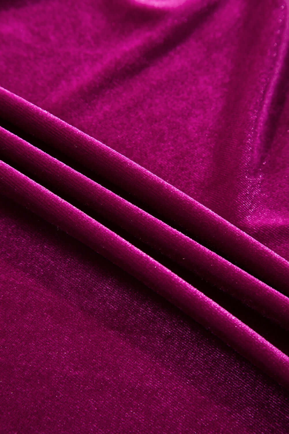 Close-up of rich pink velvet fabric with smooth texture and elegant folds.