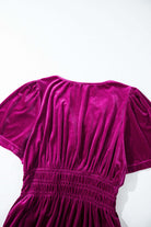 Elegant velvet dress with short sleeves and ruched waist, displayed on a bright background.