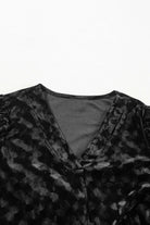 Velvet Eclipse dress with V-neck and muted animal print pattern in rich black velvet fabric close-up.