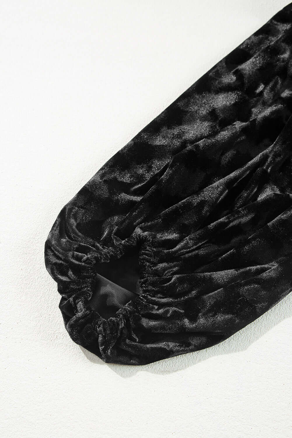 Black velvet balloon sleeve detail of the Velvet Eclipse dress with muted animal print pattern.