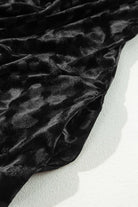 Black Velvet Eclipse dress with muted animal print pattern, showcasing luxurious fabric texture on a light background.