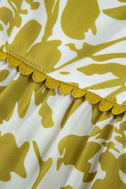 Close-up of scalloped trim on floral fabric of Spring Time Maxi Dress, showcasing modern design and vibrant colors.