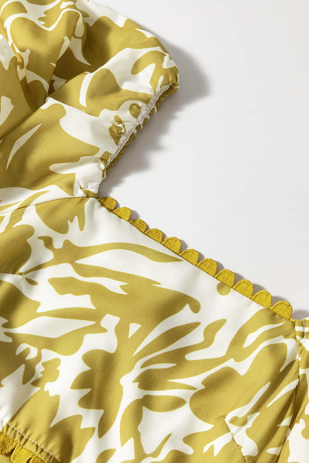 Close-up of the floral print and scalloped trim on the Spring Time Maxi Dress in bold yellow and white.