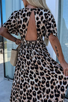 Back view of Untamed Beauty leopard print maxi dress with open back and cinched waist, exuding elegance.