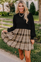 PLAID CHARM Mini Dress by Vivian-Lu featuring a black top and plaid skirt, styled with cowboy boots in an outdoor setting.