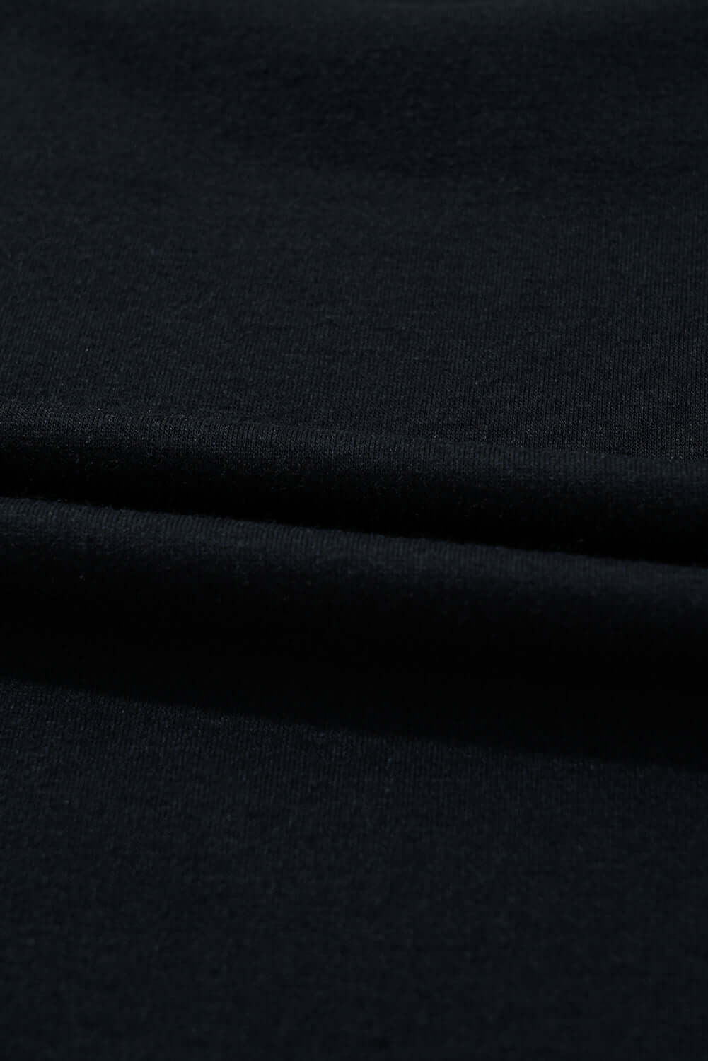 close-up of soft, black fabric showcasing its smooth texture and drape, perfect for stylish clothing.