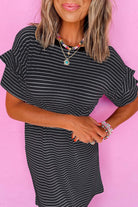 Model wearing the Perfect Pathways Dress, a black and white striped mini dress with ruffle sleeves and stylish accessories.