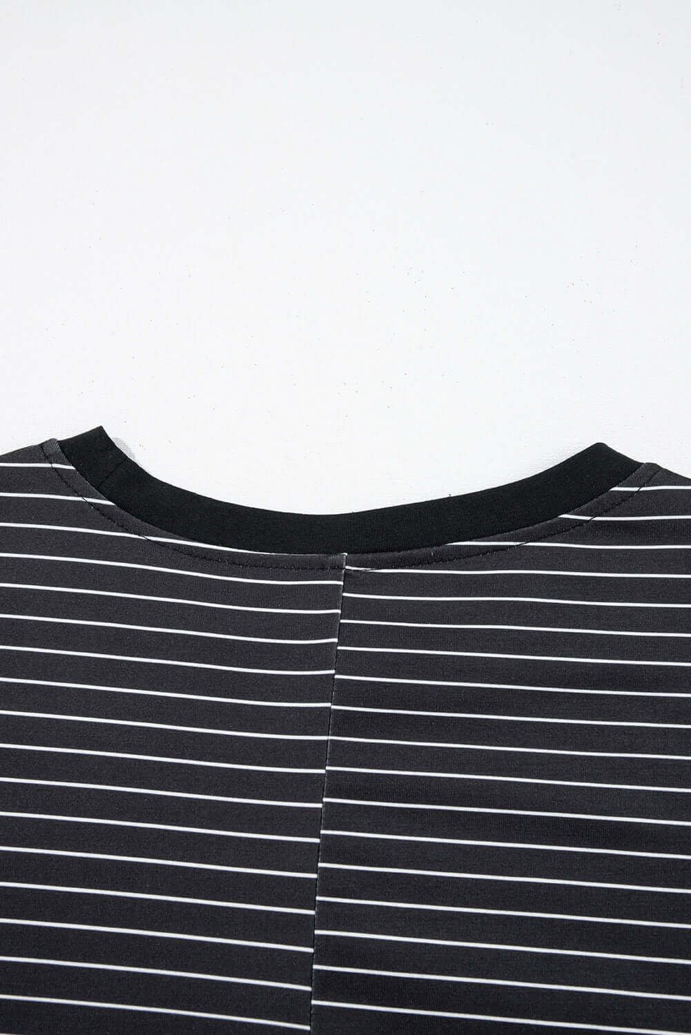 Close-up of the back neckline of the Perfect Pathways black and white striped mini dress with ruffle sleeves.