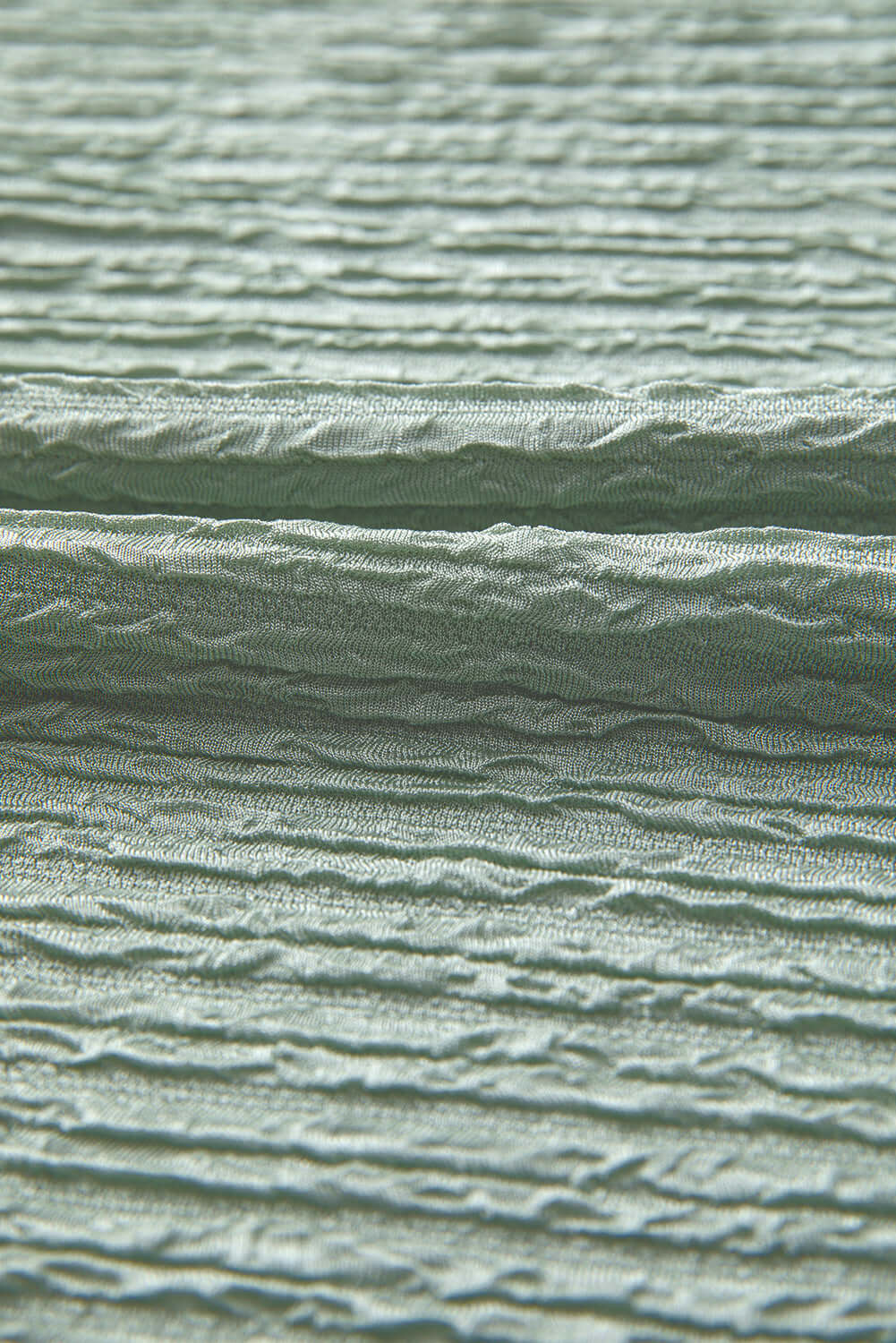 Close-up of soft sage green crinkle-textured fabric for Minted Moment Dress, highlighting its unique texture and comfort.