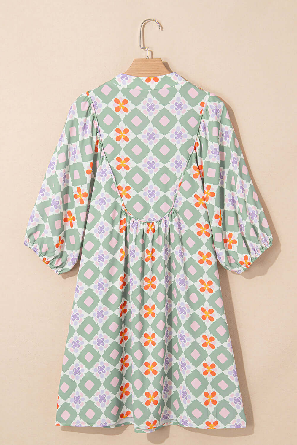 Back view of Mint Mosaic Dress featuring a mint green floral print and 3/4 puff sleeves on a hanger.