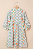 Back view of Mint Mosaic Dress featuring a mint green floral print and 3/4 puff sleeves on a hanger.