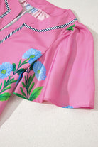 Coastal Kiss Dress in magenta with floral print and contrast trim, showcasing airy fabric and playful design.
