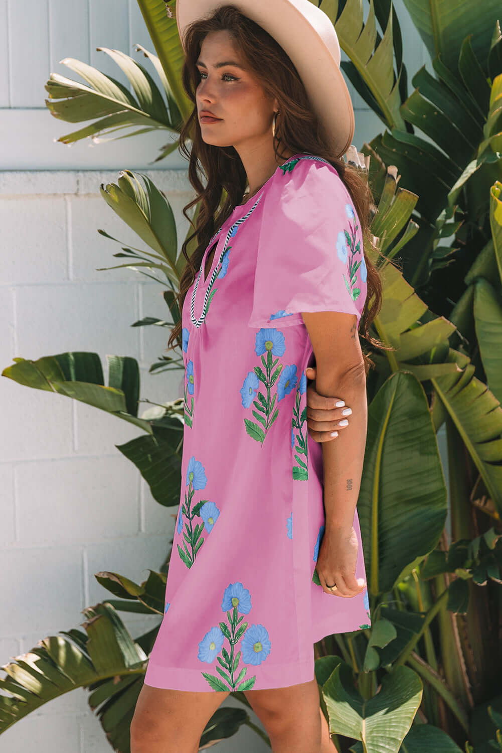 Coastal Kiss Dress in magenta with floral print, worn by a model, perfect for sunny days and seaside strolls.
