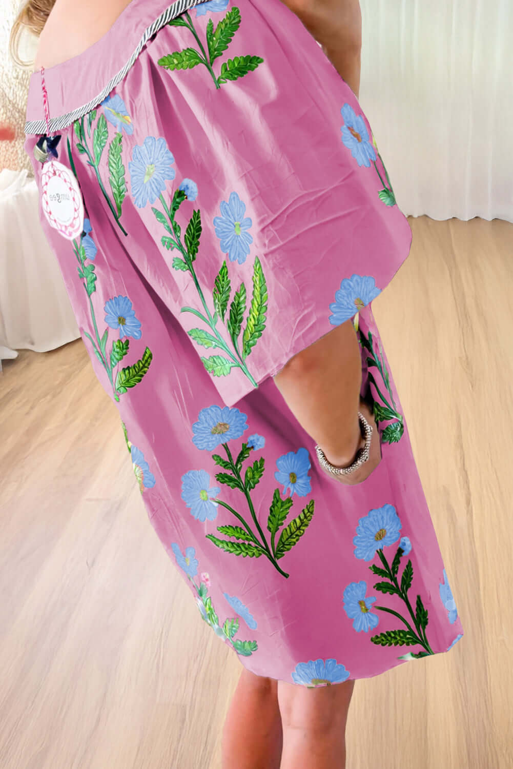 Woman wearing a magenta Coastal Kiss Dress with floral print, perfect for sunny days and seaside strolls.