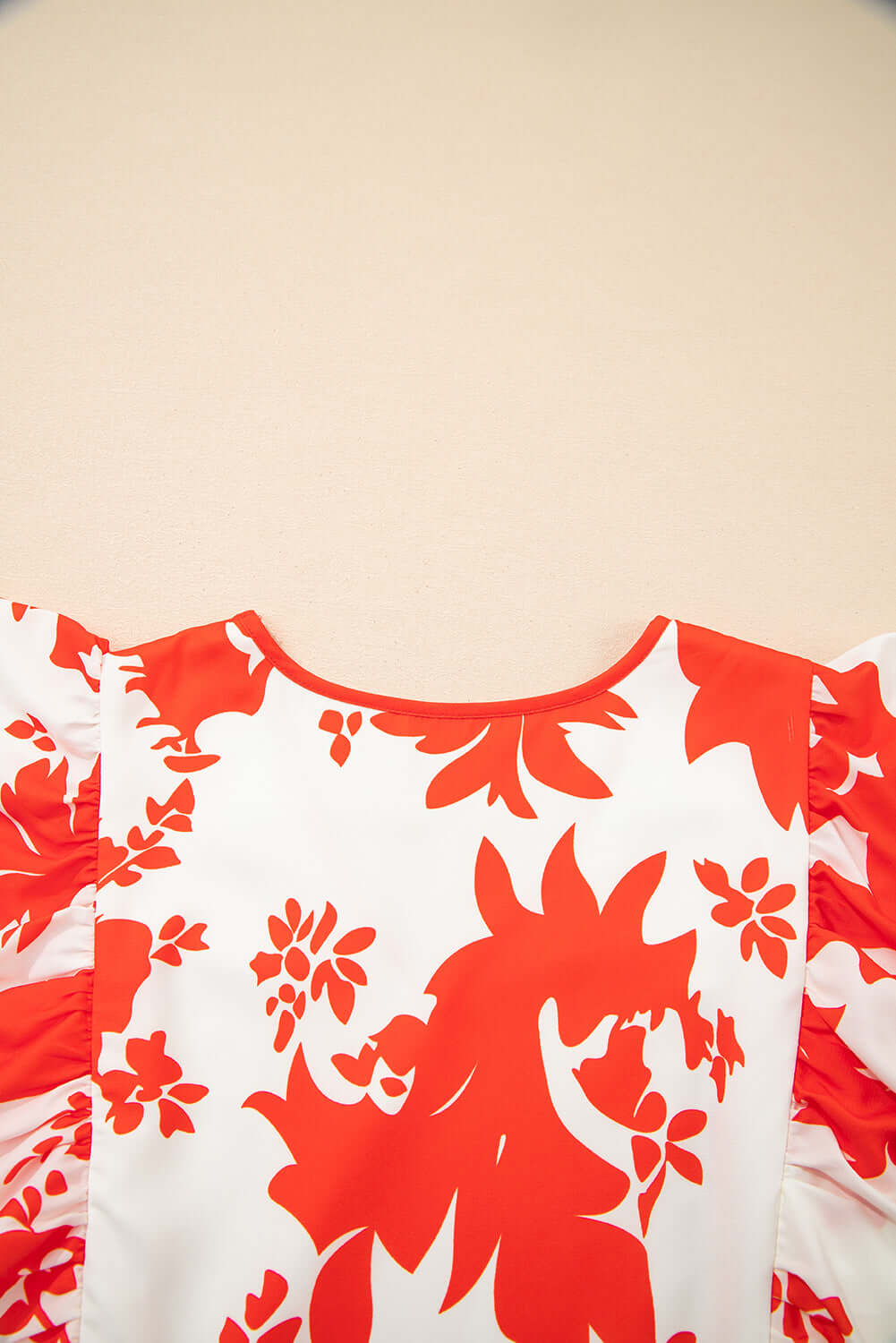 Close-up of the Salsa Garden Dress featuring bright red floral print on ivory fabric, showcasing flutter sleeves.
