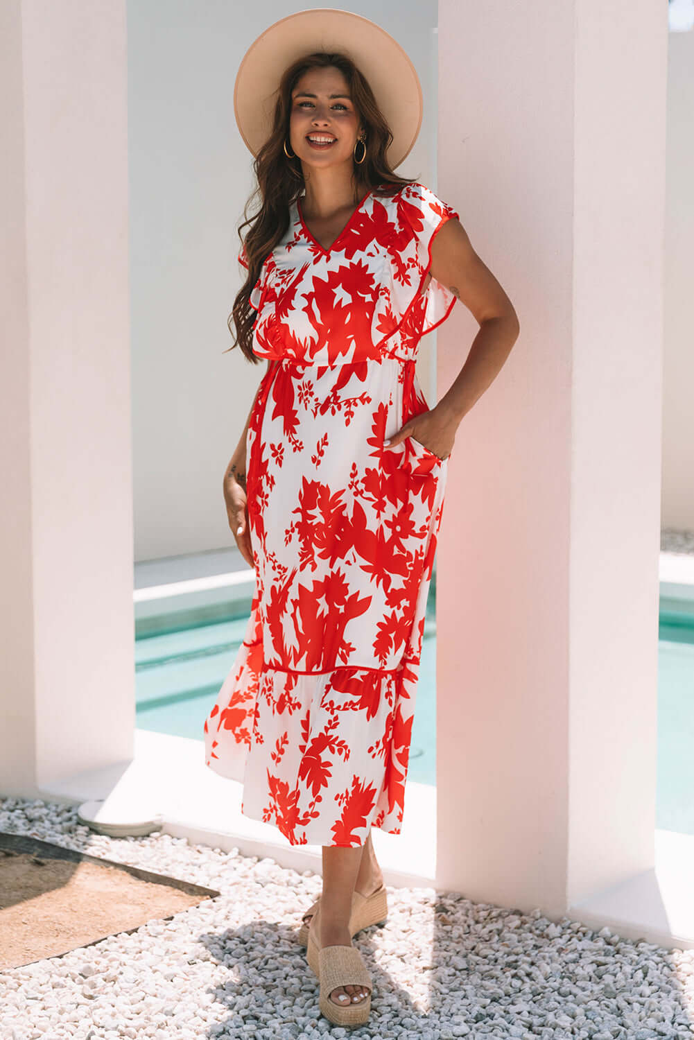 Model in a Salsa Garden Dress with red floral print, flutter sleeves, and tiered skirt, perfect for summer outings.