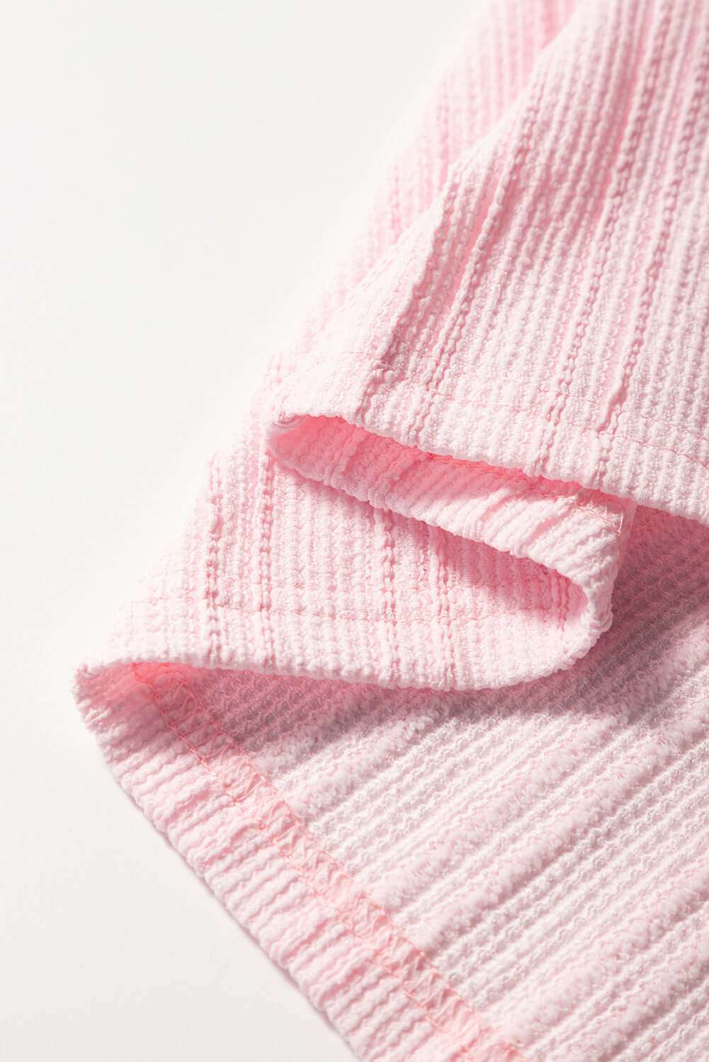 Close-up of light pink textured fabric from the Soft Serenade Set, showcasing its cozy style.