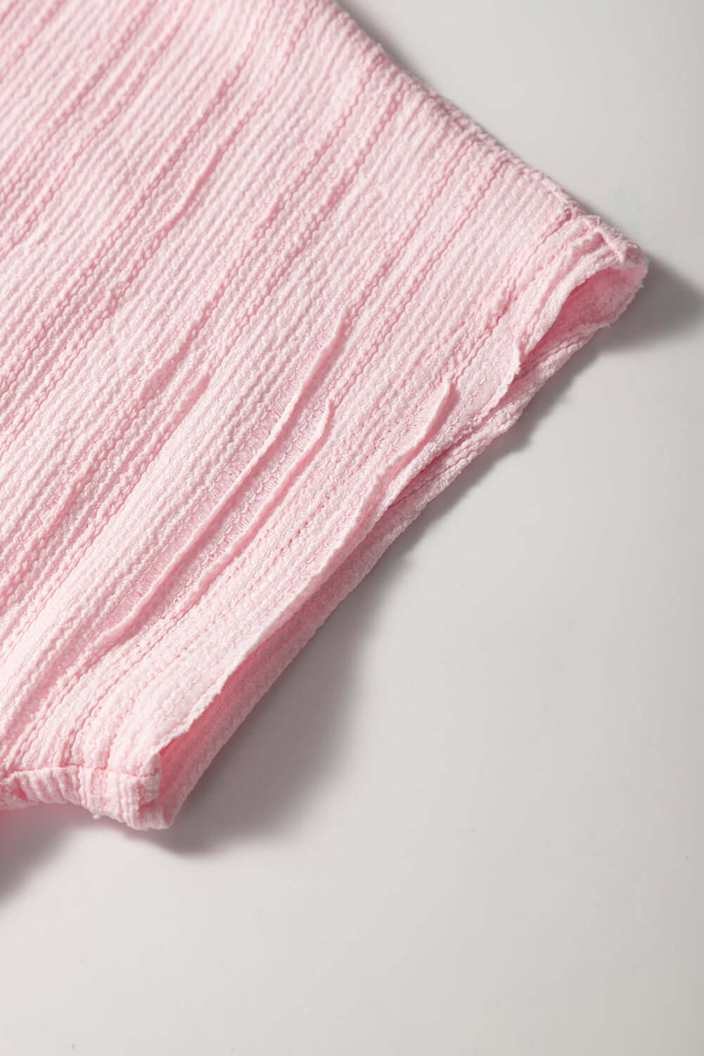 Close-up of soft pink textured fabric showcasing the short sleeve of the Soft Serenade Set.