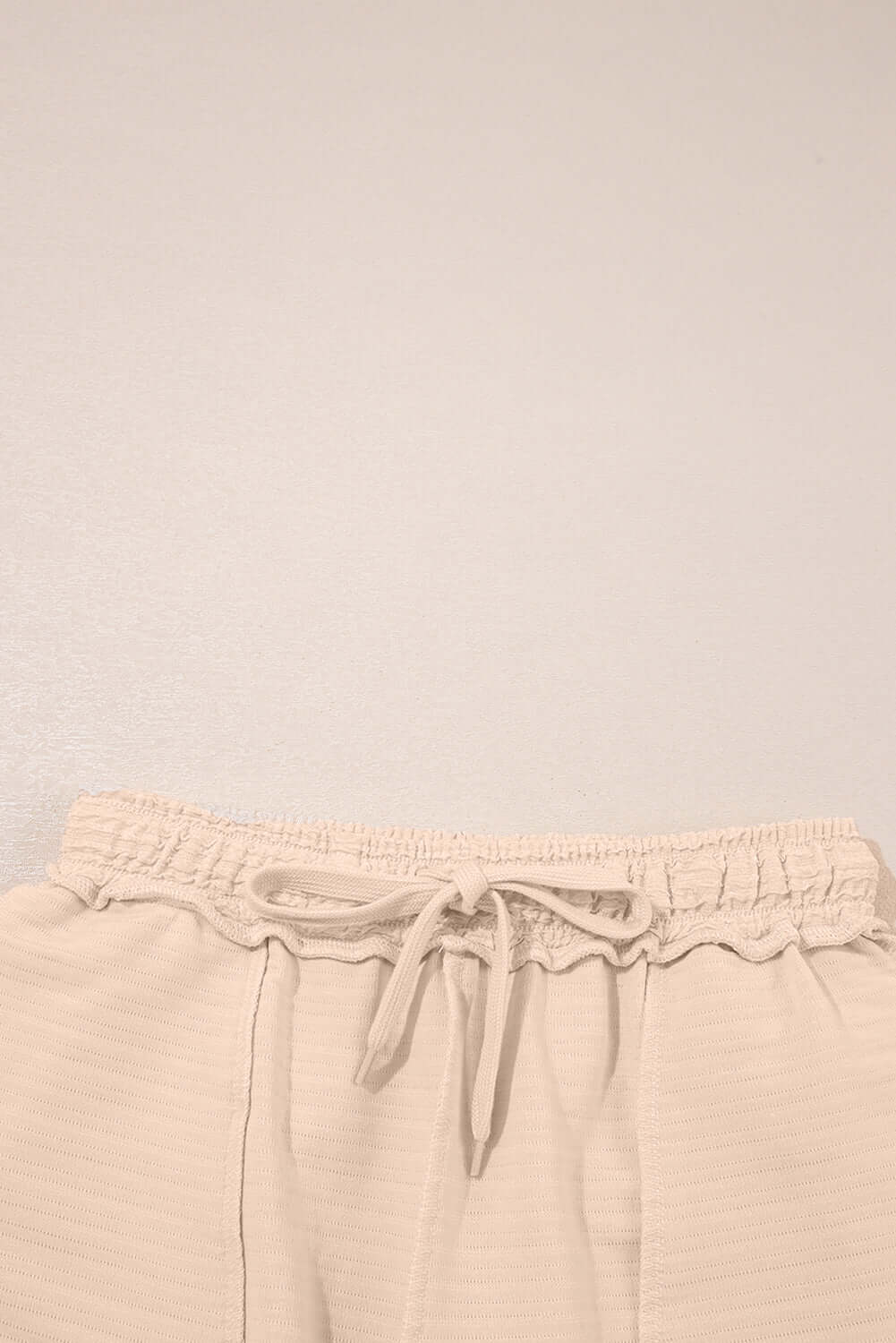 Close-up of elastic waistband shorts from Champagne Chill 2 Piece Set, showcasing soft beige fabric and tie details.