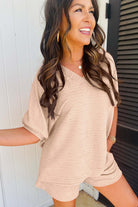 Woman smiling in textured pink V-neck top and matching shorts from Champagne Chill 2 Piece Set.