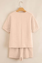 Textured pink two-piece set featuring a V-neck top and elastic waistband shorts, perfect for cozy days.