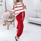 Woman wearing the TRUE STRIPES SET featuring red bottoms and a striped top in a stylish, cozy living room setting.