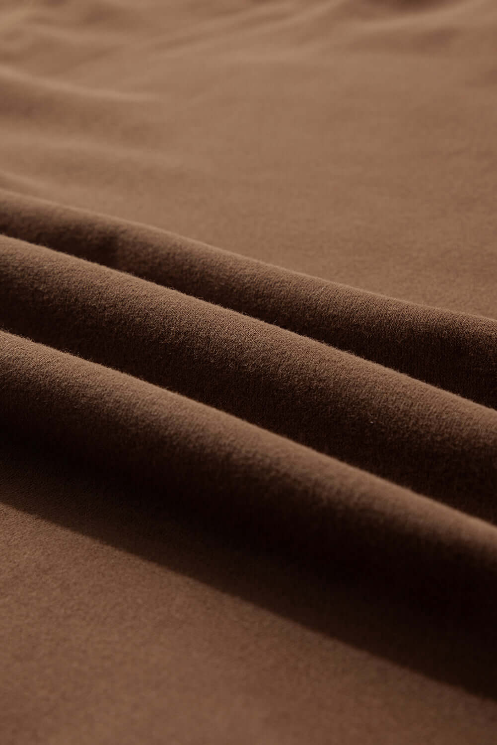 Close-up of soft cocoa fabric showcasing textured folds for the Elemental Energy Set.