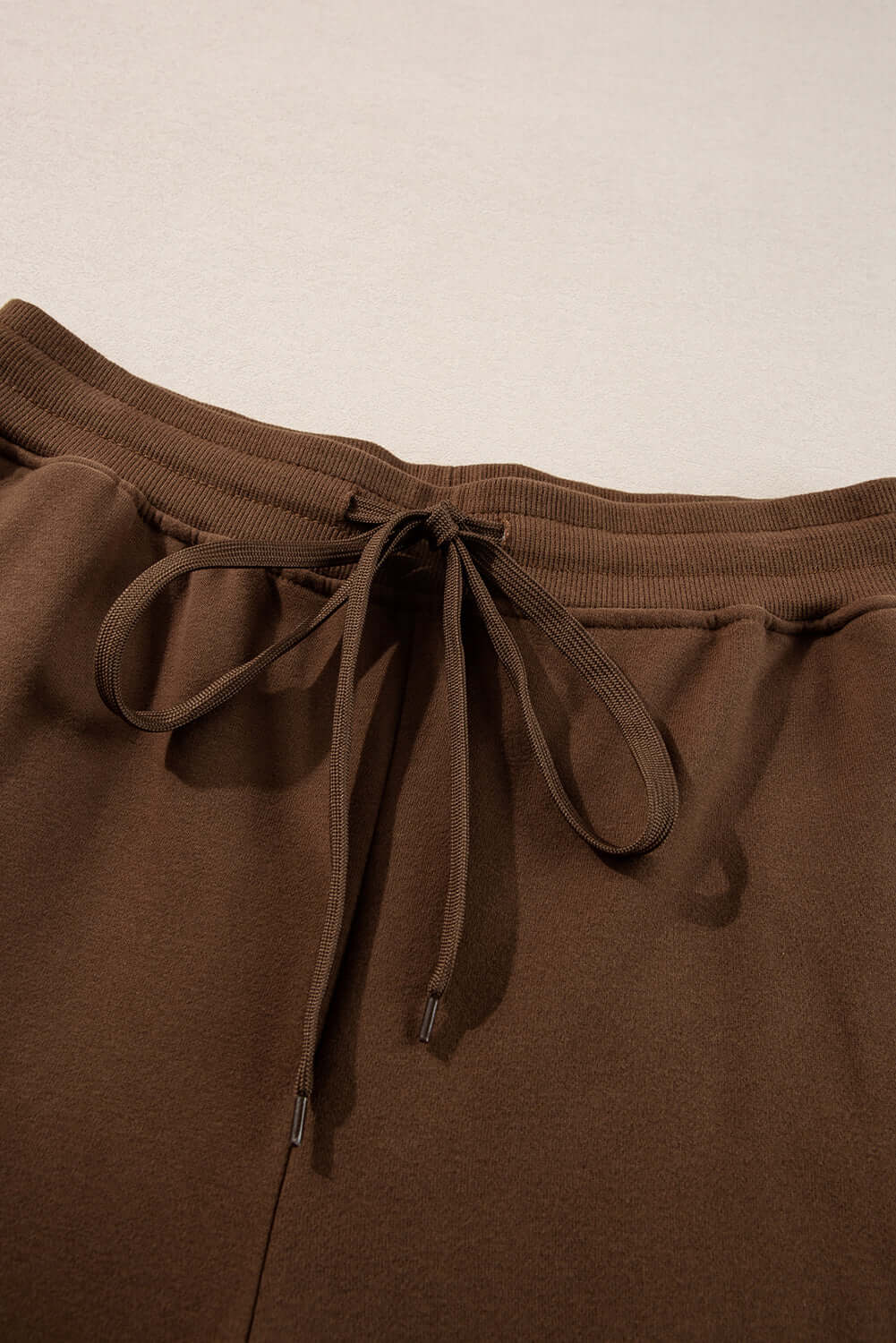 Close-up of cocoa lounge pants waistband with adjustable drawstring, part of the Elemental Energy Set.