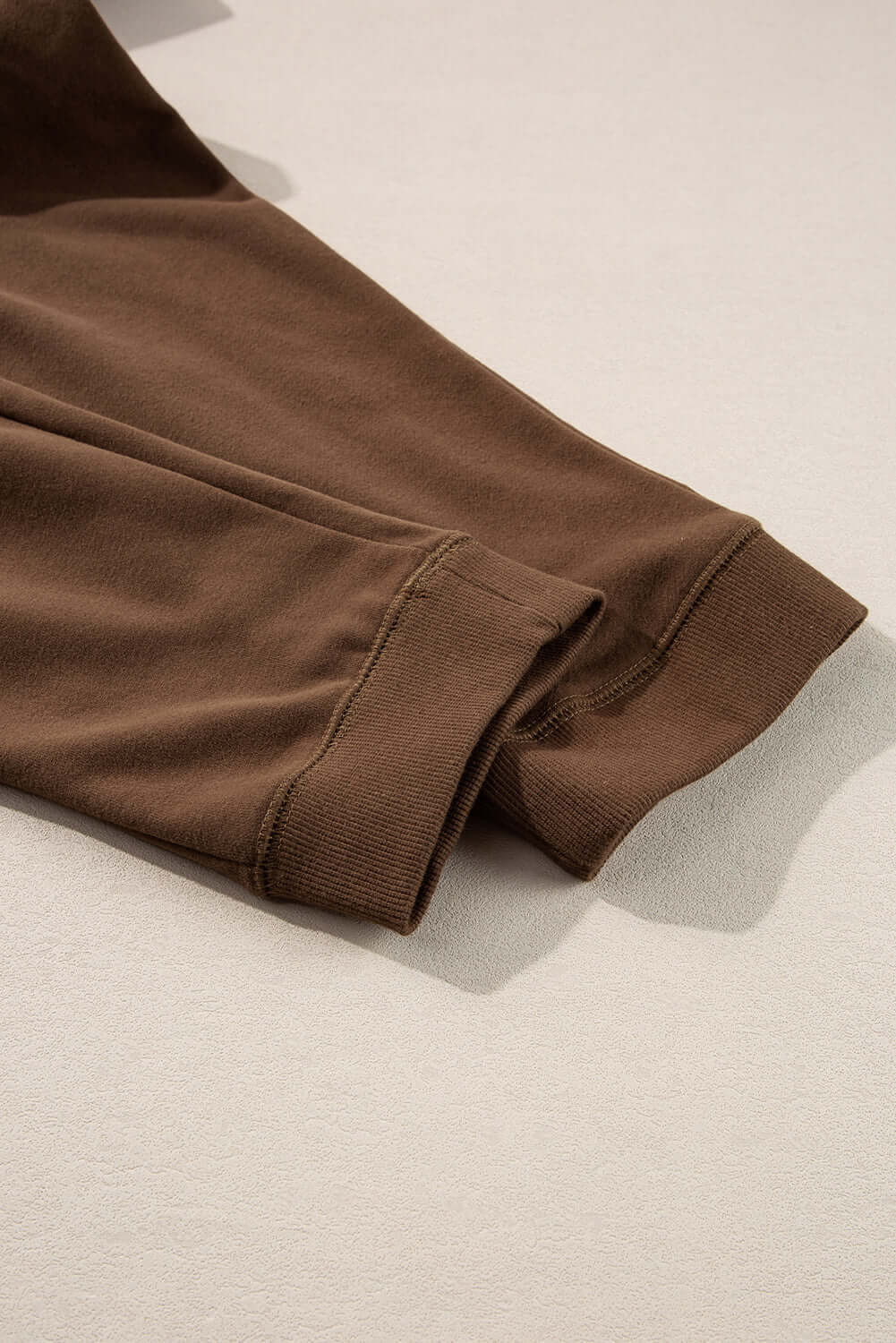 Cozy cocoa sweatshirt sleeve detail showing high-quality fabric and relaxed fit. Ideal for stylish comfort.