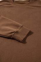 Close-up of a cocoa brown high low sweatshirt featuring a crew neck and relaxed fit sleeve. Ideal for casual comfort.