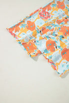 Vibrant floral fabric in tangerine and coral hues showcasing roses and blooms, perfect for sunset stroll pants set.