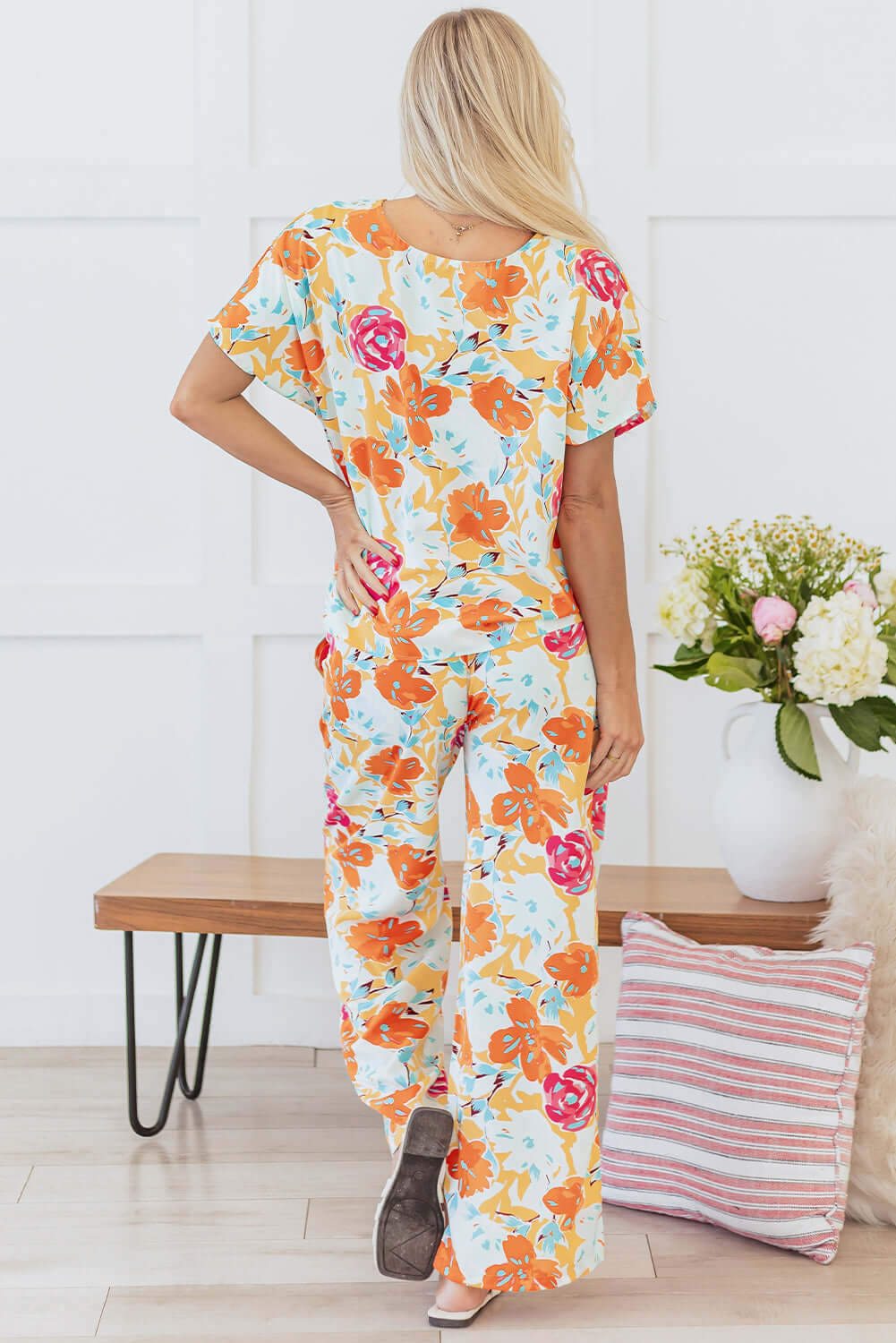 Back view of the vibrant tangerine floral Sunset Stroll pants set featuring wide-leg pants and a relaxed-fit top.