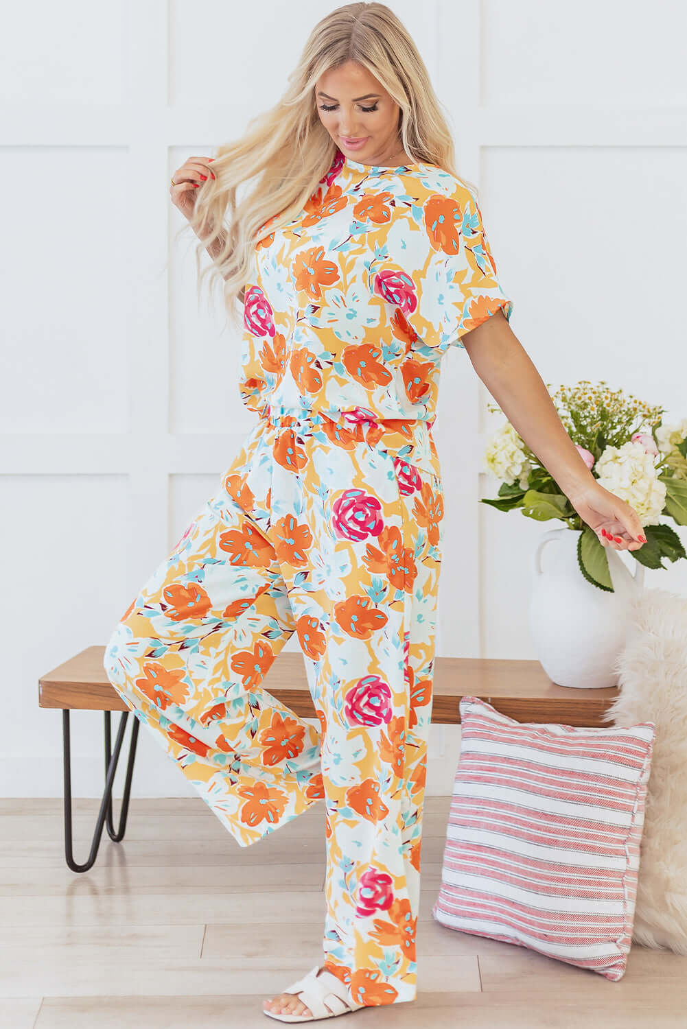Model wearing the Sunset Stroll Pants Set, featuring a tangerine floral top and matching wide-leg pants.