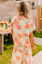 Back view of Sunset Stroll Pants Set featuring vibrant floral prints in tangerine, coral, and pink for a stylish summer look.