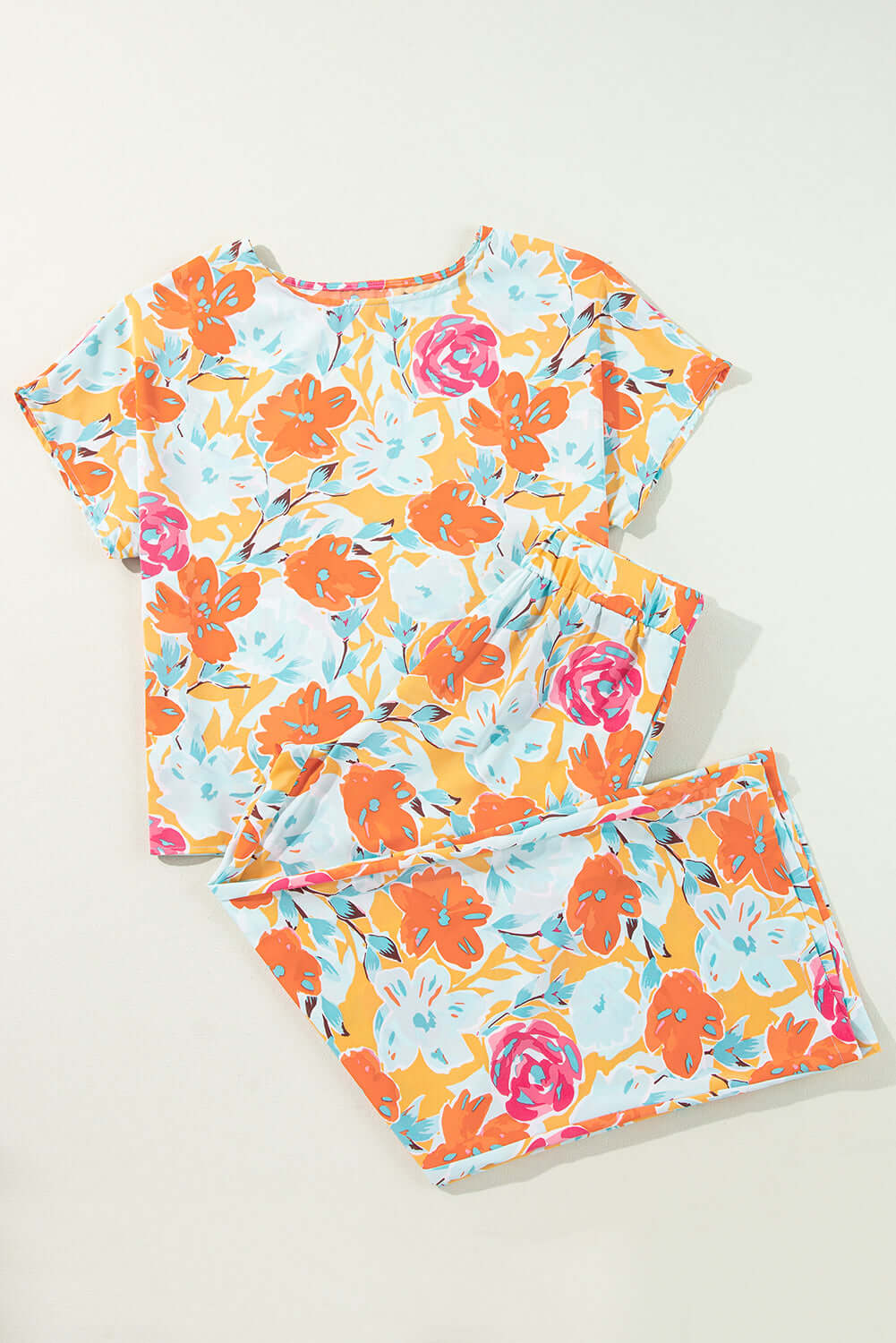 Sunset Stroll Pants Set featuring a vibrant floral print in tangerine, coral, pink, and mint colors, including a top and matching pants.