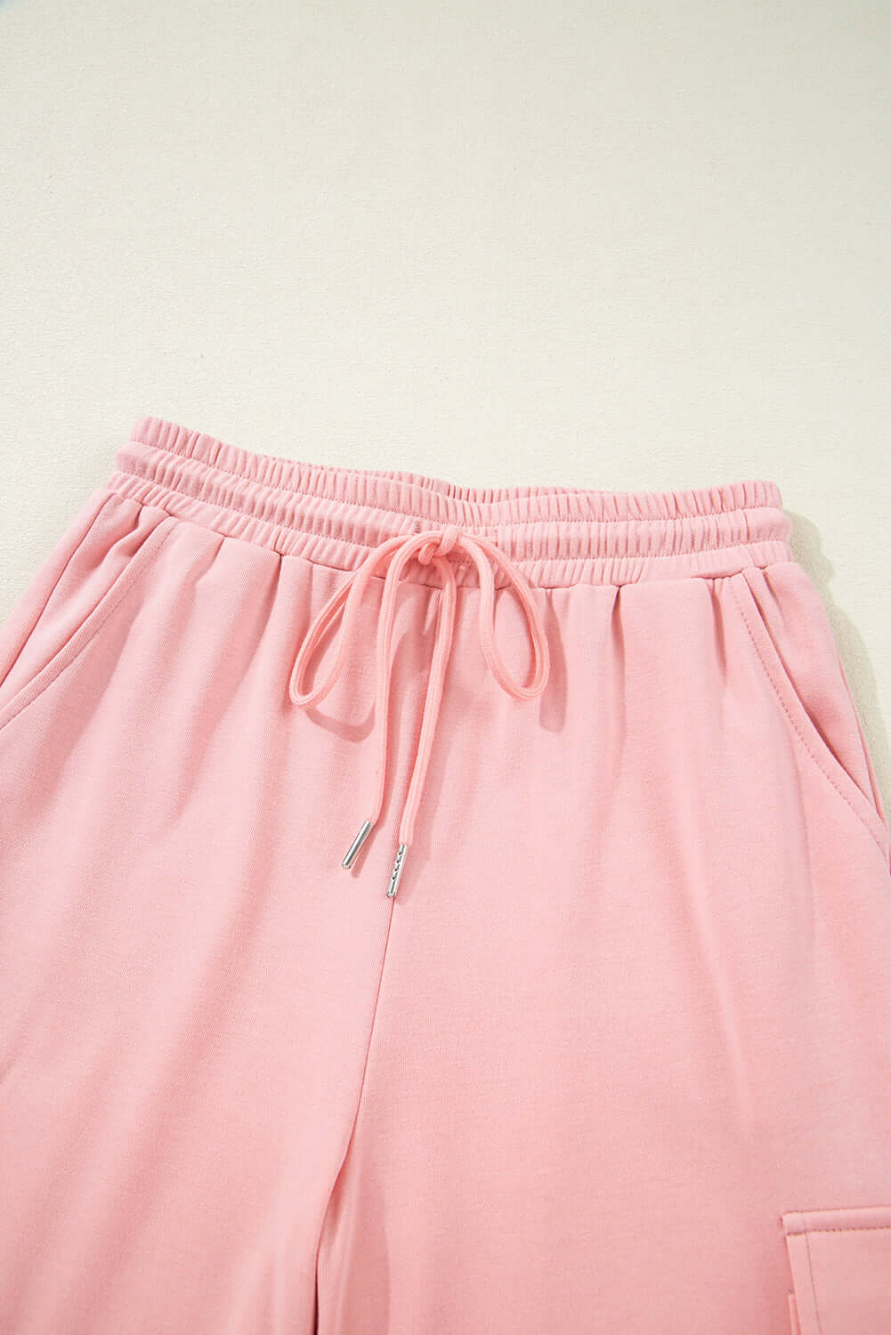 Close-up of pink cargo sweatpants featuring an elastic waistband and side pockets, part of the Pink Cloud lounge set.