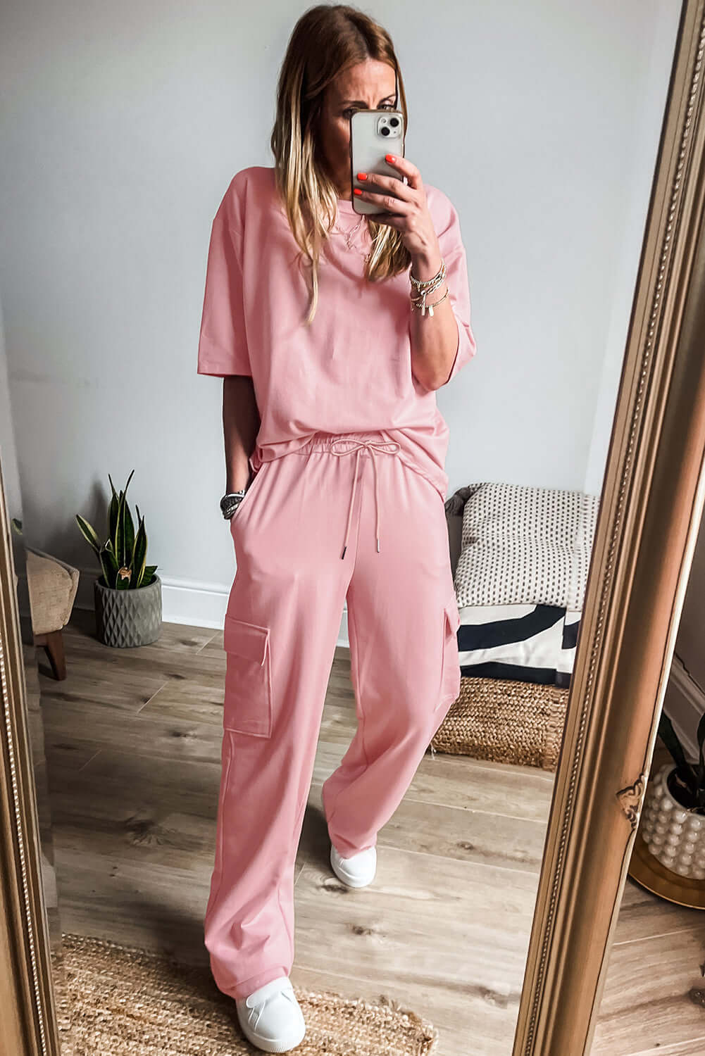 Woman in a pink cloud 2-piece lounge set featuring a relaxed tee and cargo sweatpants.