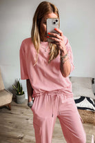 Model wearing the pink cloud lounge set featuring a half sleeve tee and cargo sweatpants.