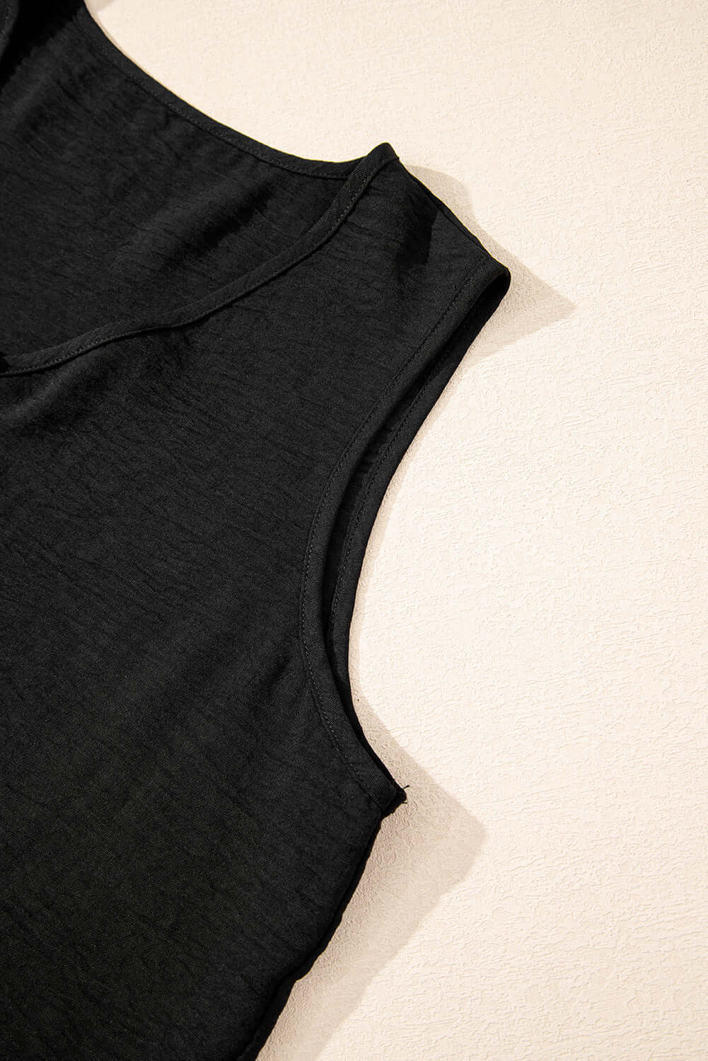 Close-up of black crop vest from Oasis Moment 2-piece pants set, featuring a boxy neckline and sleeveless design.