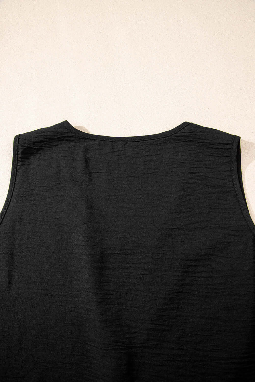 Back view of Oasis Moment black buttoned vest, showcasing its sleek design and textured fabric.